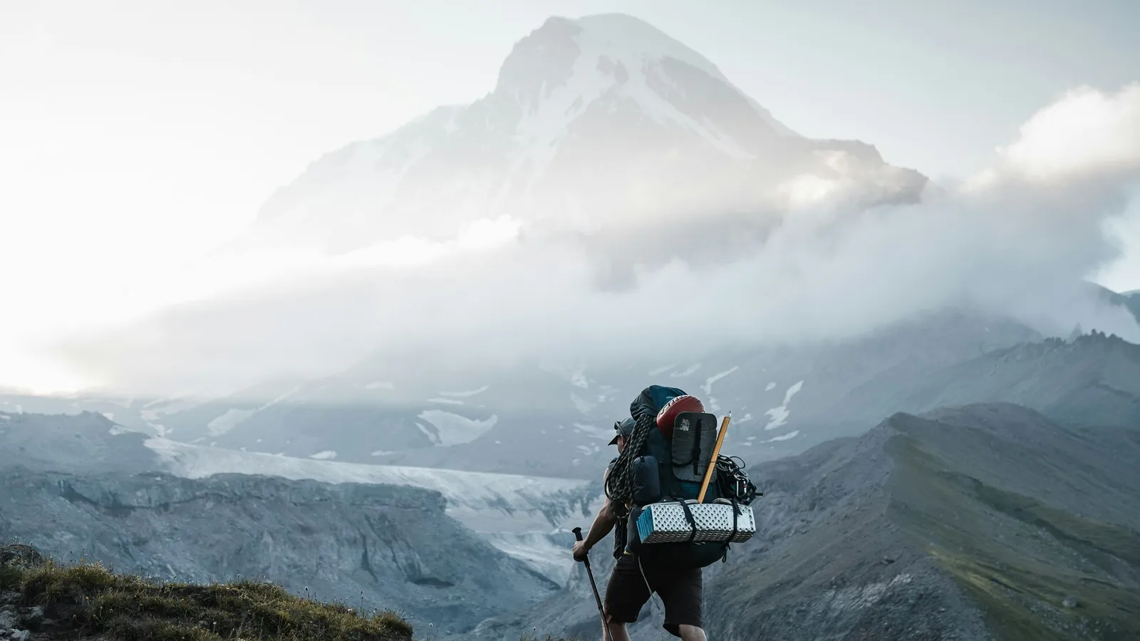 Hiker with a loaded backpack climbing a mountain trail