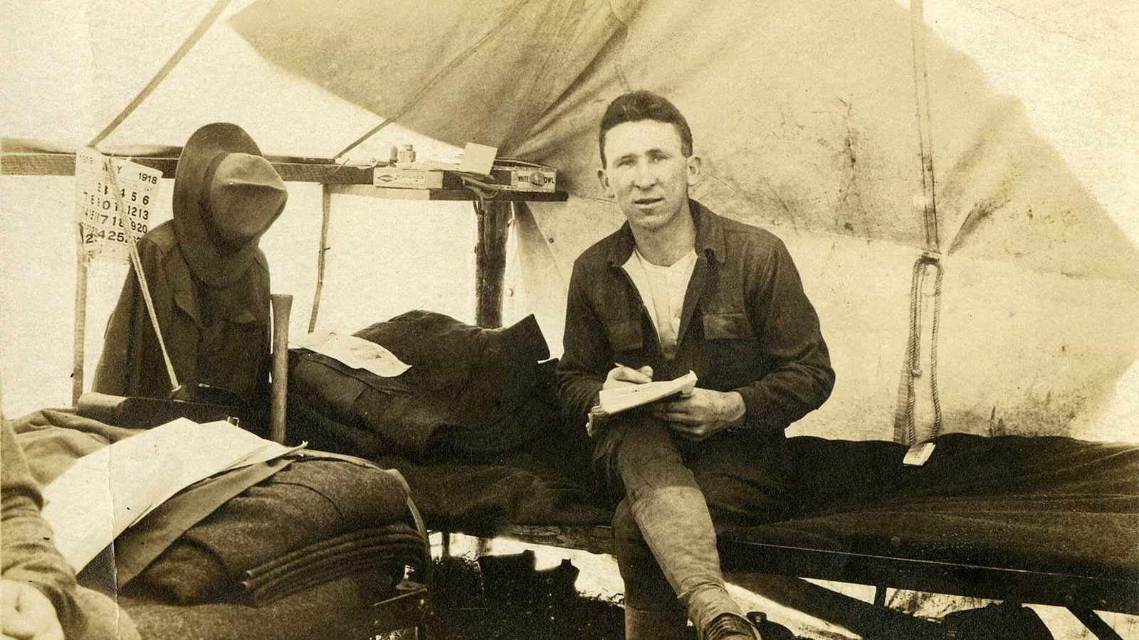Historical view of a camp cot inside a tent