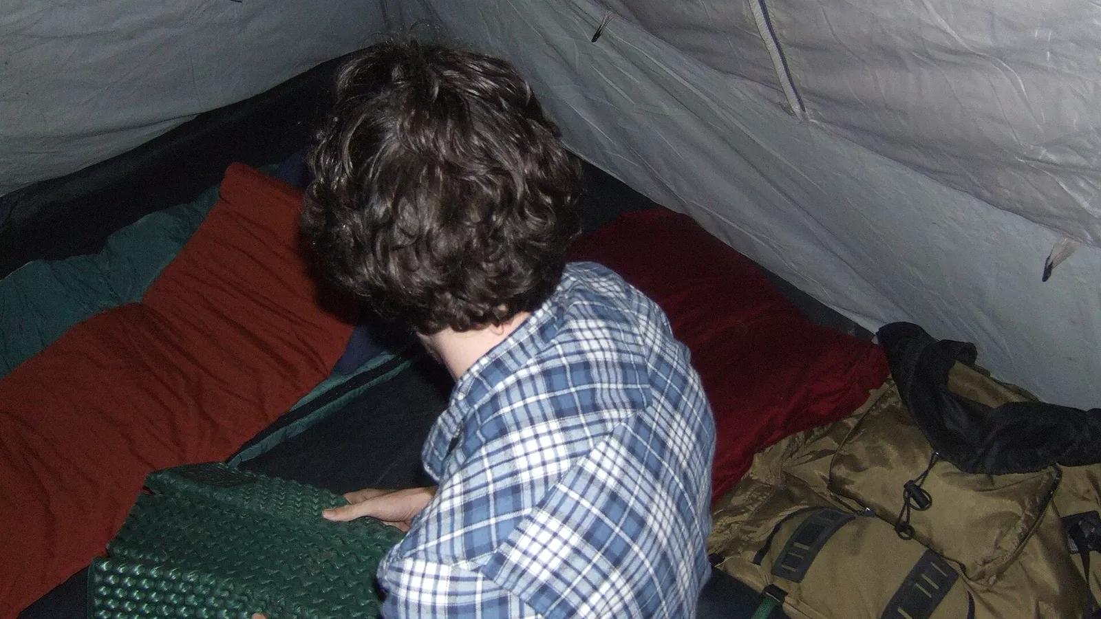 Camper arranging egg-crate foam inside a tent