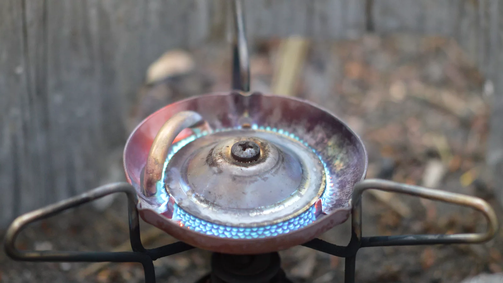 Compact camping stove being used outdoors at a developed campsite