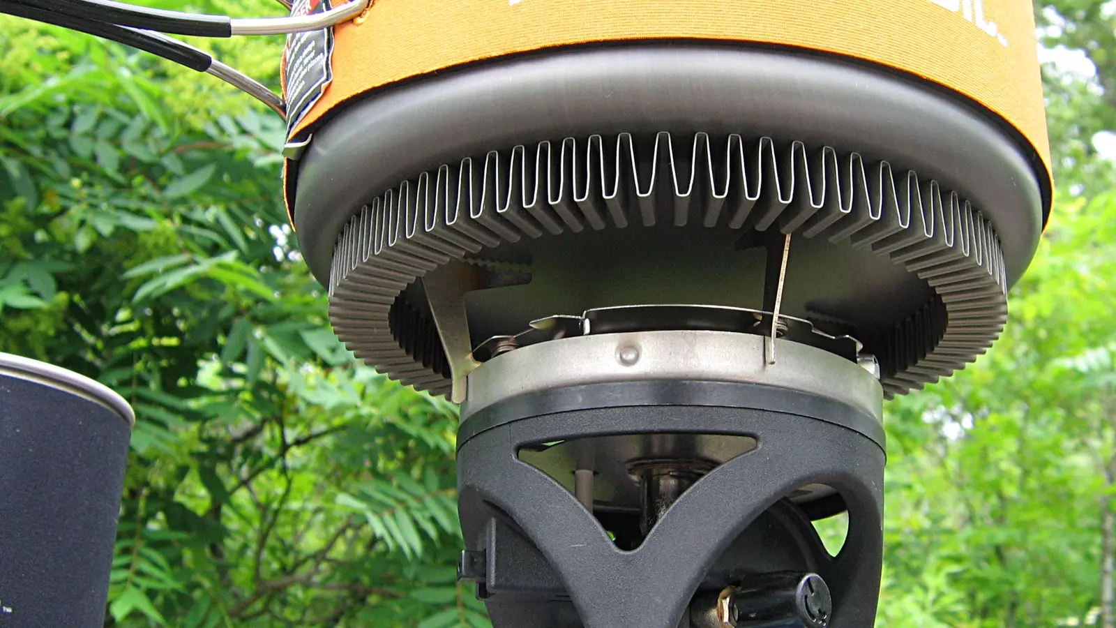 Compact fuel-burning camping stove supporting a cooking pot
