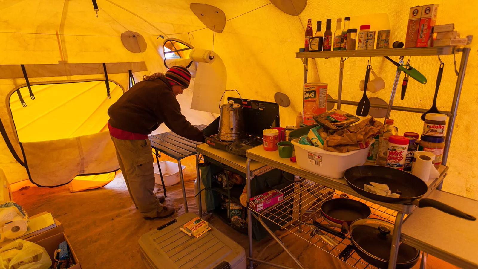 Camp cook cleaning a table before preparing dinner