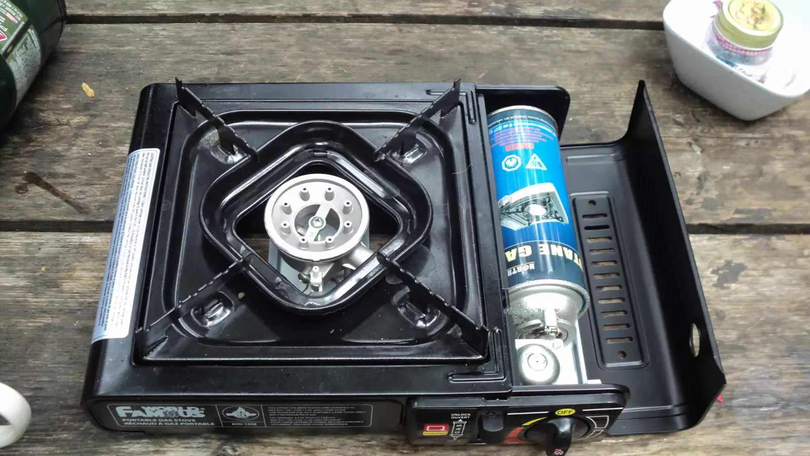 Portable butane camping stove with its cylinder compartment open