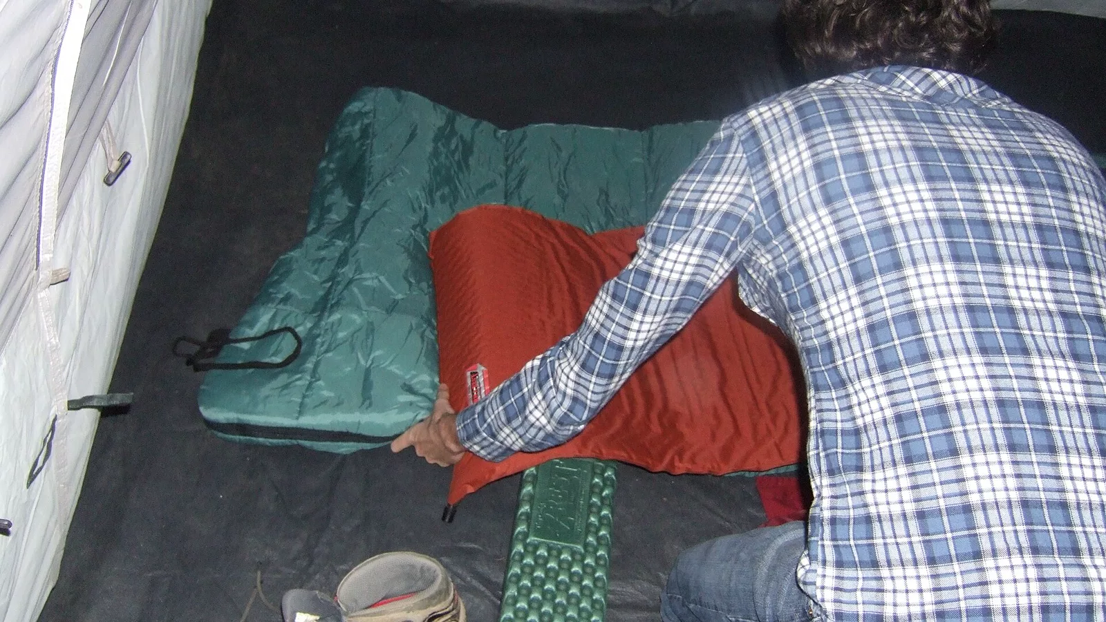 Camper arranging sleep gear inside a tent