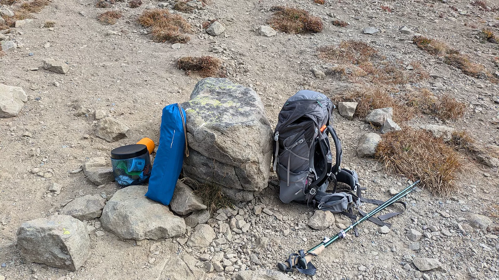 Backpacking sleeping pad and shelter gear at an alpine campsite